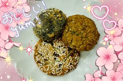 Three different types of cookies on a white plate set on a pink tablecloth.