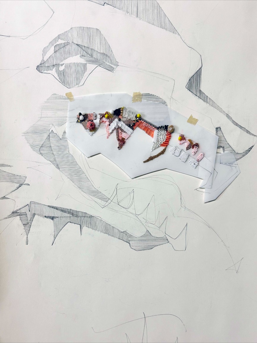 An illustration of a dog with its mouth open, drawn in black and white on white paper. Colorful beaded embellishments and jewelry samples in pink, red, white, black, orange, and gold are arranged across the dog’s body, creating a mixed-me