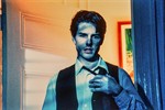 a blue-lit Tom Cruise pulling off his tie in a yellow-lit doorway