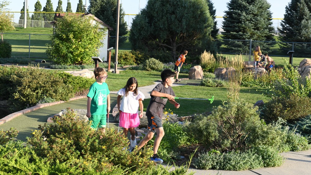 Teens playing miniature golf outside at the Family FunPlex