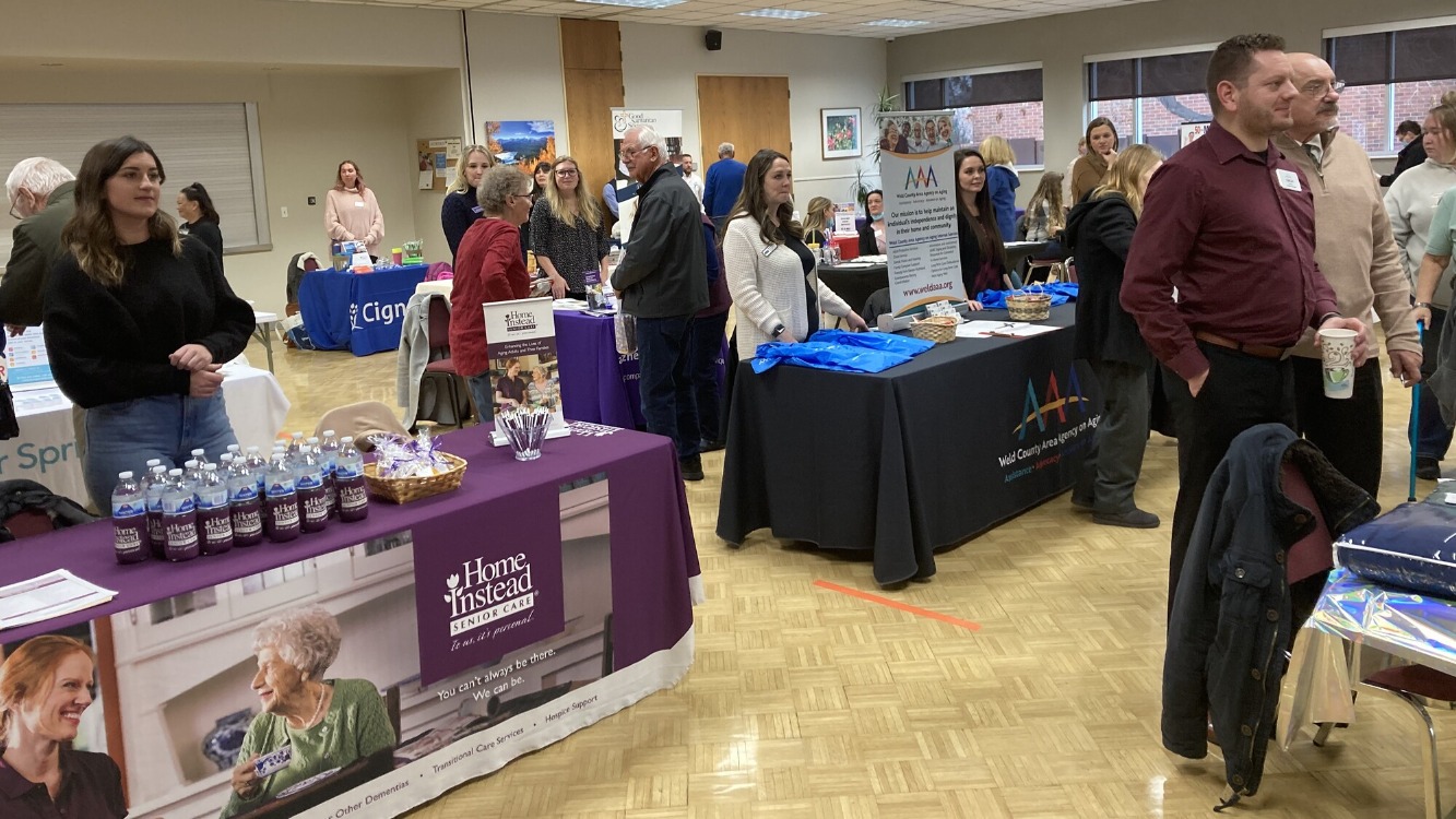 an event with tables to learn info and people standing at tables