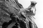 A samurai in white wielding a sword and fighting on a cliff face with another in black A samurai in white wielding a sword and fighting on a cliff face with another in black