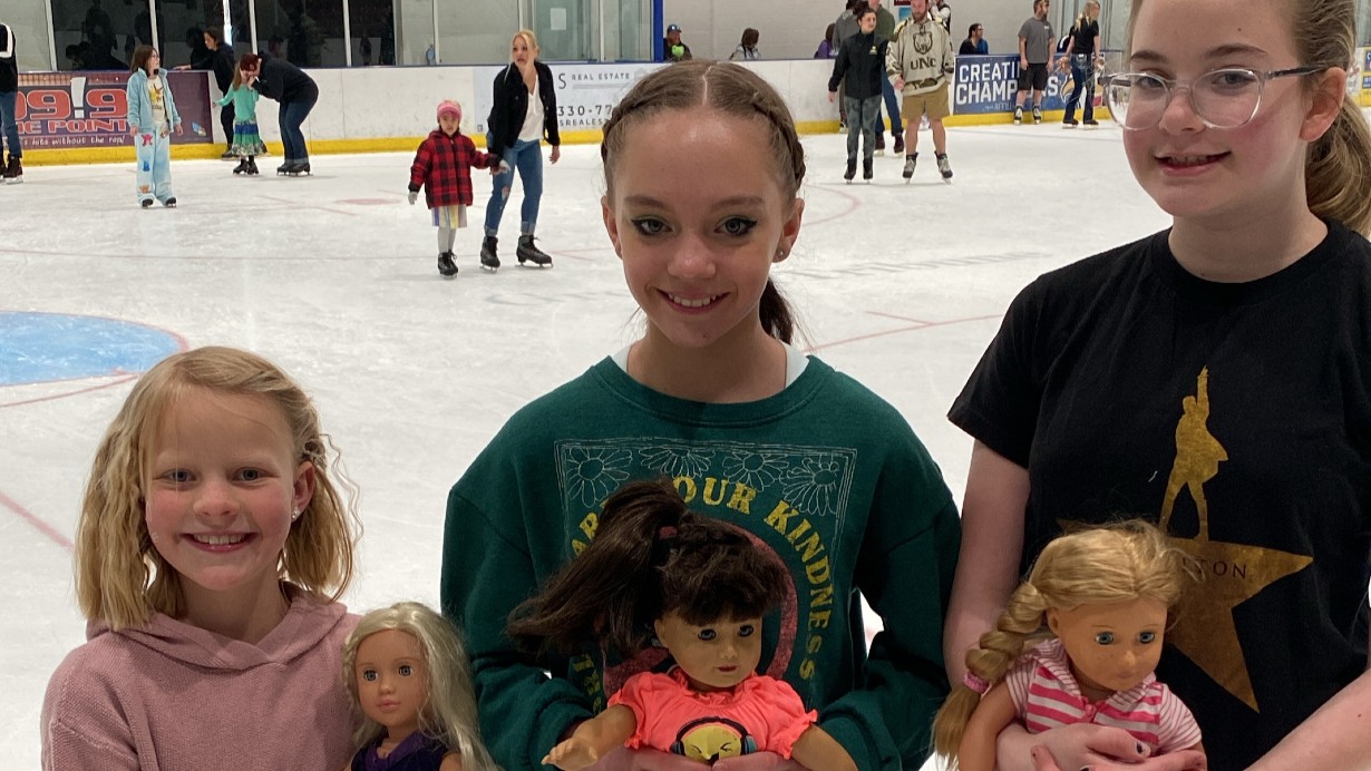 Three girls hold their American Girl dolls while skating at the Greeley Ice Haus