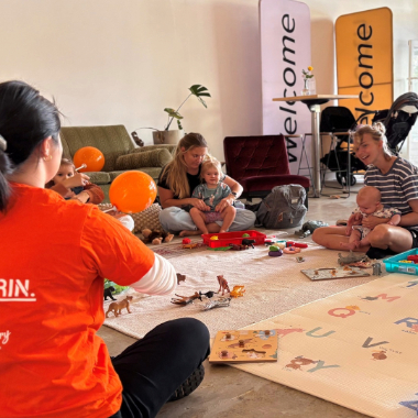 A group of parents and young children enjoying a Rhyme Time session