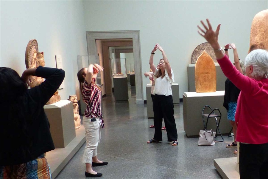 A group of people doing yoga in an art gallery. A group of people doing yoga in an art gallery.