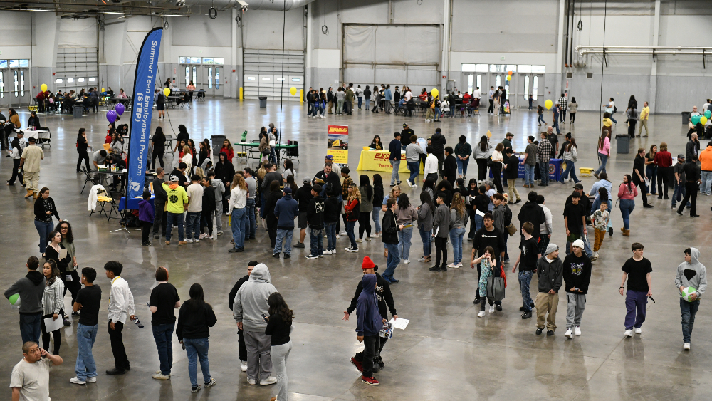 Young adults line up to visit employers during the job fair at Island Grove Events Center.