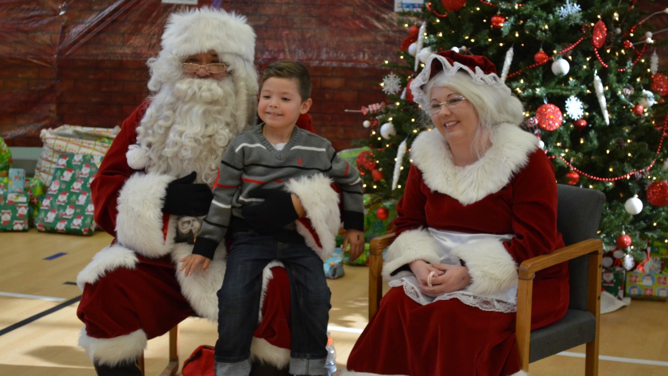 Santa and Mrs Claus visit with a young boy at the Rodarte Community Christmas party