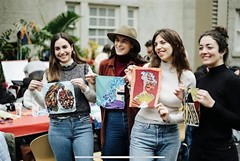 A group of people holding handmade artwork. 