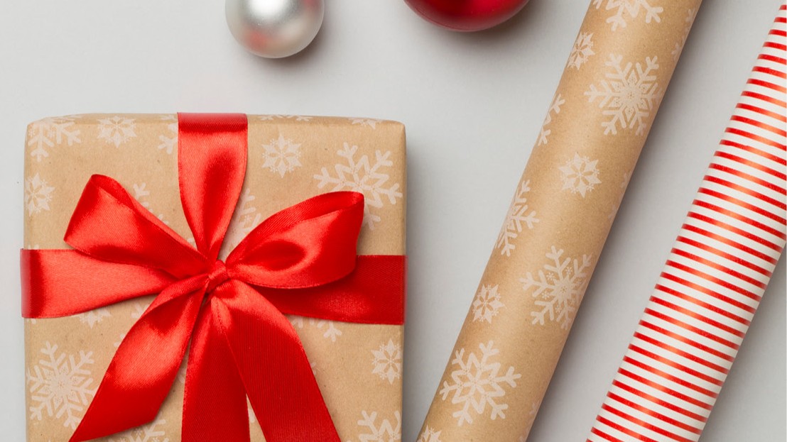 Holiday paper, ornament balls, and a package with a red ribbon