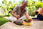 Page Chang holds a wooden mallet in one hand and a piece of barkcloth in the other Page Chang holds a wooden mallet in one hand and a piece of barkcloth in the other