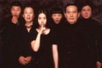 a Korean family all dressed in black as if for a portrait with the younger daughter making the