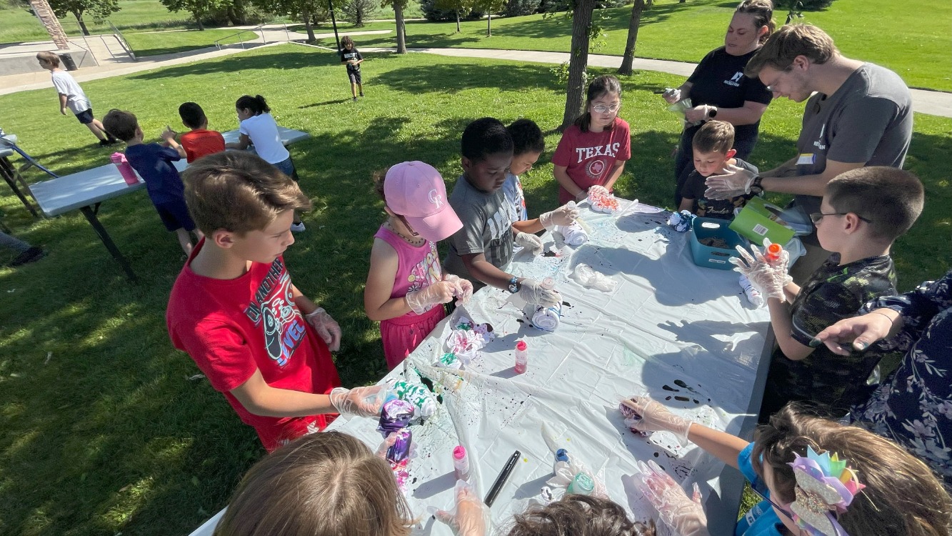 Campers create artwork outdoors during summer camp at the FunPlex