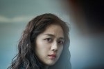 Close-up of young Korean woman looking concernedly at a man who is out of focus
