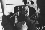 Close-up of a Japanese man hitting another through a rice paper window Close-up of a Japanese man hitting another through a rice paper window