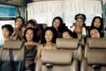 A busload of young Korean women, sweating and serious A busload of young Korean women, sweating and serious