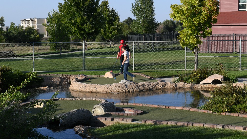 Two boys play miniature golf at the Family FunPlex