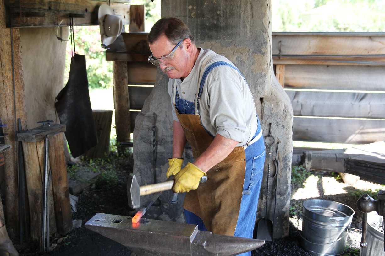 blacksmith working at forge with glowing metal