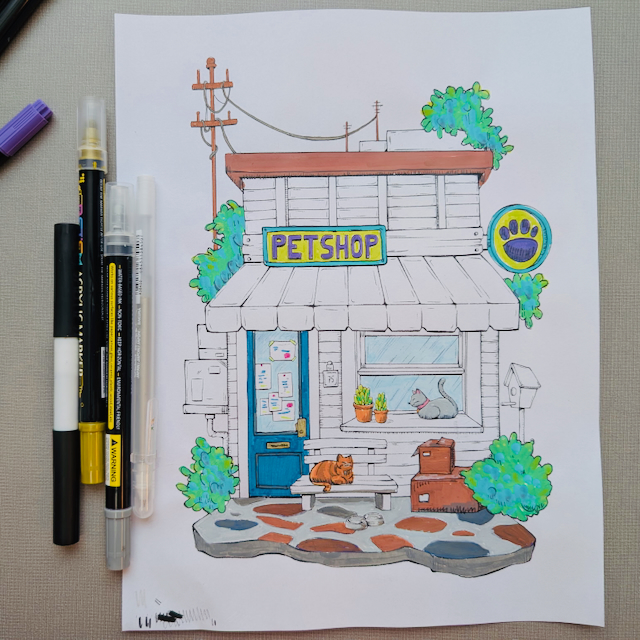 A photo of a partially completed coloring page of a petshop with a gray and an orange cat.