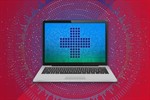 A laptop with a medical cross on the screen with a blue, green background A laptop with a medical cross on the screen with a blue, green background