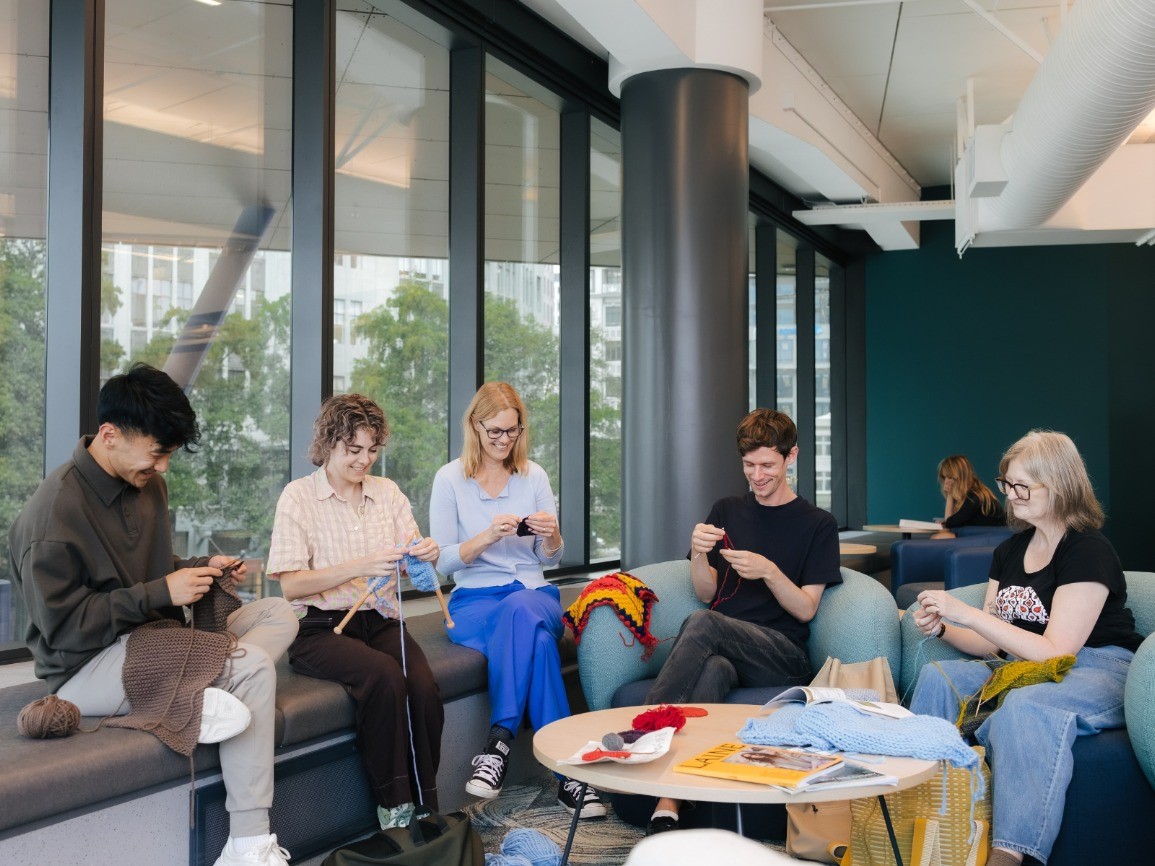 People knitting in a group around a table
