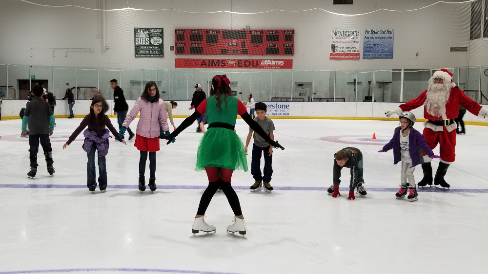Santa and his elf offer an ice skating lesson at the Greeley Ice Haus during the Skate with Santa event